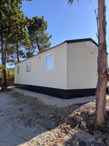 ein großes weißes Gebäude mit Bäumen davor in der Unterkunft School MotorhomePark - Aldeamento Turístico in Óvoa