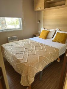 ein Schlafzimmer mit einem großen Bett mit gelben Kissen in der Unterkunft School MotorhomePark - Aldeamento Turístico in Óvoa