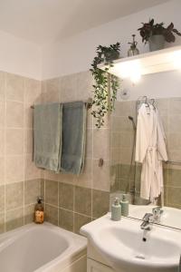 Beaune Levernois - Piscine Chauffée, Sauna et Golf في ليفيرنوا: حمام مع مغسلة وحوض استحمام