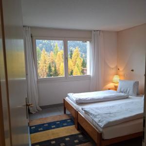 a bedroom with two beds and a large window at Ferienapartment Weitsicht in Biel