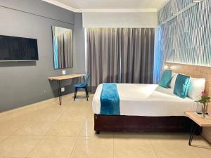 a hotel room with a large bed and a desk at Bayside Self Catering and Hotel 14 Monty Naicker Pinestreet Durban in Durban +18 photos