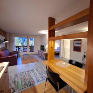 a kitchen and living room with a wooden table at Ferienapartment Weitsicht in Biel