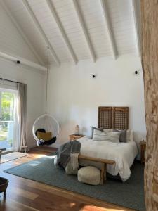 een slaapkamer met een groot bed en een tapijt bij The Red Hill Barn in Main Ridge