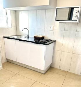 a kitchen with a sink and a microwave at Bayside Self Catering and Hotel 14 Monty Naicker Pinestreet Durban in Durban