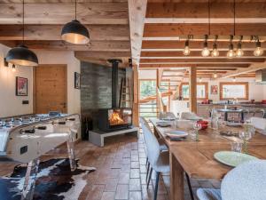 een eetkamer met een fornuis en een open haard bij Chalet CLADIE - Private Jacuzzi & Sauna - View of Mont Blanc range - By Cozee Rentals in Les Houches