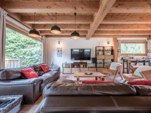 een woonkamer met een leren bank en een tafel bij Chalet CLADIE - Private Jacuzzi & Sauna - View of Mont Blanc range - By Cozee Rentals in Les Houches