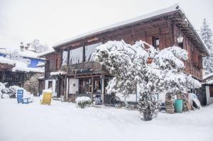 een besneeuwd huis met een boom ervoor bij Мандулова Къща in Koprivshtitsa