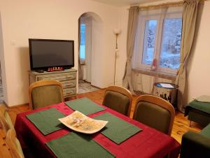 uma sala de jantar com uma mesa e uma televisão em Wiejski Dom w Karkonoszach em Mysłakowice