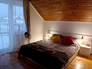 um quarto com uma cama com teto de madeira em Wiejski Dom w Karkonoszach em Mysłakowice