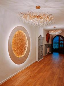 a living room with a chandelier and a large orb on the wall at Forsthaus Faistenau in Hintersee