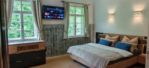 a bedroom with a bed with a tv on the wall at Forsthaus Faistenau in Hintersee +54 photos