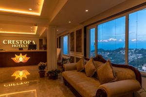 Hotel Tenzing's Glory Darjeeling في دارجيلنغ: غرفة معيشة مع أريكة أمام نافذة