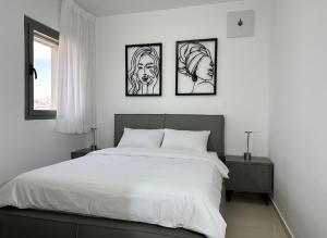 Un dormitorio con cuatro cuadros en la pared. en דירות נופש רויאל פארק מביאים את הבית לחופשה, en Eilat 32 fotos más
