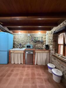 a kitchen with a blue refrigerator and a stove at La aldea de lug in Rozagás