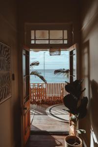 an open door with a view of the ocean at Stoep By Ideas Cartel in Kalk Bay