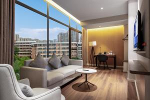 ein Wohnzimmer mit Couch und großem Fenster in der Unterkunft Holiday Inn Express Yichang Riverside by IHG in Yichang
