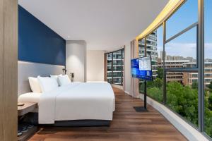 ein Hotelzimmer mit einem Bett und einem großen Fenster in der Unterkunft Holiday Inn Express Yichang Riverside by IHG in Yichang + 68 Fotos