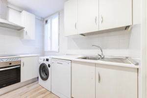 eine weiße Küche mit Spüle und Geschirrspüler in der Unterkunft Amati Boutique Coliving Madrid in Madrid
