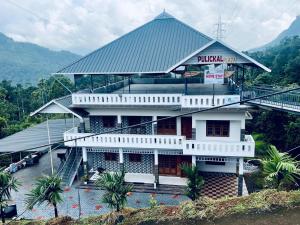 a white building with a sign on top of it at Mulberry homestay Munnar in Anaviratty