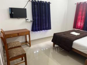 a bedroom with a bed and a chair and a tv at Mulberry homestay Munnar in Anaviratty