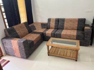 a living room with a couch and a coffee table at Mulberry homestay Munnar in Anaviratty