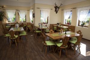 a restaurant with wooden tables and chairs and windows at Victoria Camping Bella Austria in Peterdorf