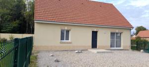 una pequeña casa blanca con techo rojo en Gîte les lys à Lignières Chatelain, en Lignières-Châtelain
