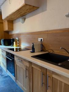 eine Küche mit Spüle und Arbeitsplatte in der Unterkunft La Ruche, Maison chaleureuse de 5 personnes in Aigueblanche + 6 Fotos