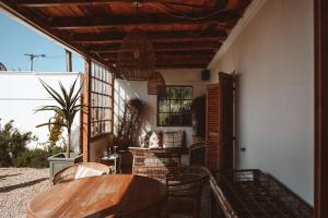 a patio with a wooden table and chairs and a table at Stoep By Ideas Cartel in Kalk Bay