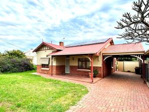 una casa con techo rojo y entrada de ladrillo en 3BR Guest House near Adelaide CBD Joslin 5070, en Evandale