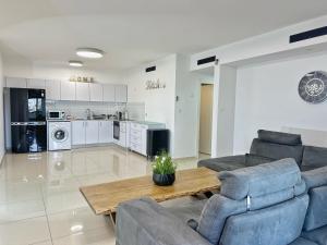 Una sala de estar con sofás y una mesa y una cocina. en דירות נופש רויאל פארק מביאים את הבית לחופשה, en Eilat