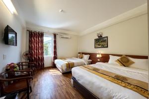 a hotel room with two beds and a window at Long Anh Hotel in Lao Cai