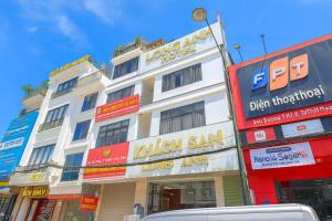 a tall white building with signs on the side of it at Long Anh Hotel in Lao Cai