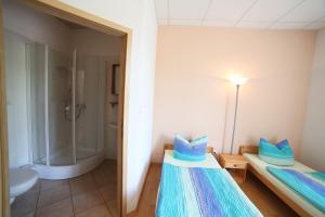 a bathroom with two beds and a shower at Gästehaus am schmalen See UG haftungsbeschränkt in Lauchhammer