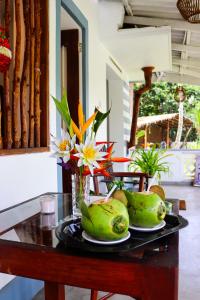 Sky Villa Unawatuna في يوناواتونا: طاولة عليها طبقين من الفواكه والزهور