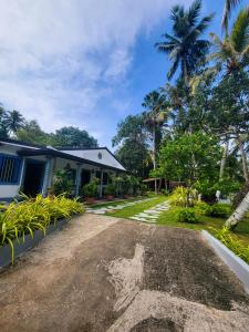 Sky Villa Unawatuna في يوناواتونا: منزل أمامه ممر ترابي