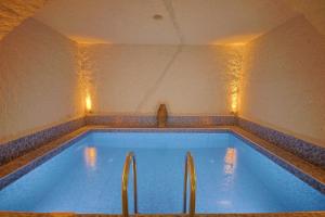 a large swimming pool with lights in a room at My Cave Suites in Nevsehir