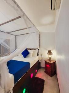 Sky Villa Unawatuna في يوناواتونا: غرفة نوم بسرير ازرق وبيض ومصباح