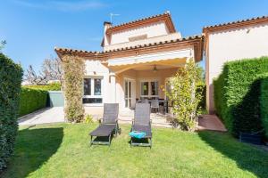 une maison avec deux chaises dans la cour dans l'établissement Al Alba - Serene escape with shared swimming pool, à Bonmont Terres Noves