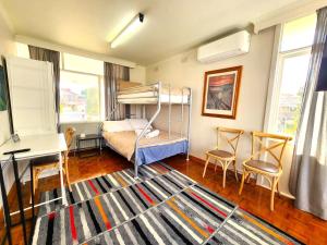 a bedroom with a bunk bed and a desk at Large quad guest room 6 with well-equipped kitchen in Highett +34 photos