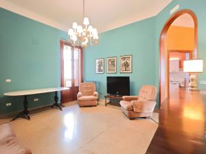 a living room with blue walls and a table and chairs at Dimora Cavour in Monopoli