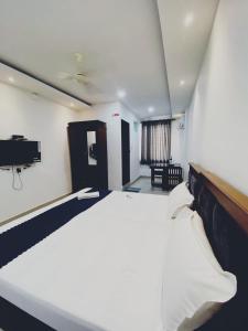 a bedroom with a large white bed in a room at Metro Residency in Perintalmanna +1 photo