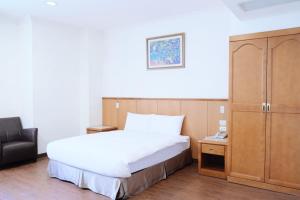 a bedroom with a large bed and a cabinet at 丰居一中 Via Garden Hotel in Taichung +20 photos