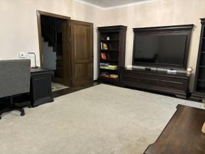 een woonkamer met een flatscreen-tv en een bureau bij Casa Carolina in Alba Iulia