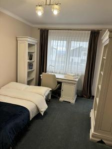 een slaapkamer met een bed, een bureau en een raam bij Casa Carolina in Alba Iulia
