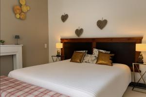 a bedroom with a large white bed with hearts on the wall at Proche Avignon au calme in Les Angles Gard