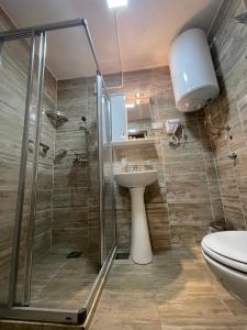 um banheiro com chuveiro, pia e vaso sanitário em Apartmani Resna Budva em Budva mais 42 fotografias