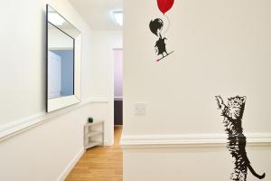 Sidemersey Livings - Spacious Loft for bigger groups - Very Central and Cosy في ليفربول: غرفة بها قطة وبالون معلق على الحائط