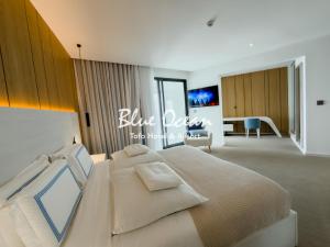 a bedroom with a large bed and a living room at Blue Ocean Tofo Hotel & Resort in Inhambane