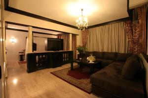 a living room with a couch and a tv at Imperial Holiday Hôtel & spa in Marrakech